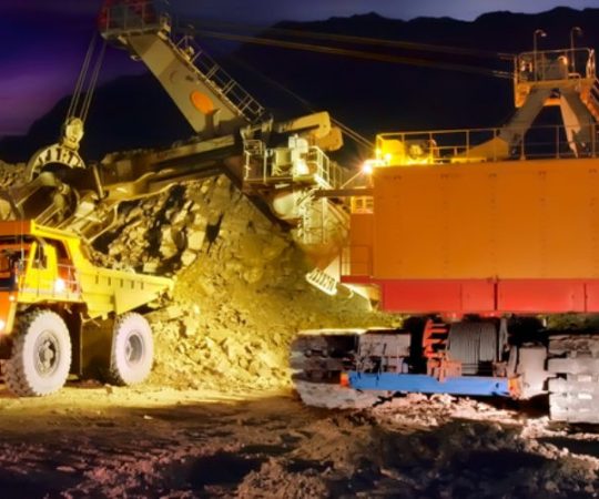 A picture of a big yellow mining truck at worksite (night)