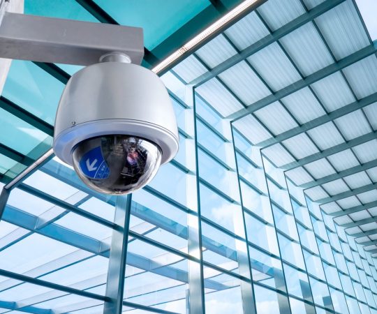 Security, CCTV camera for office building at night in London.